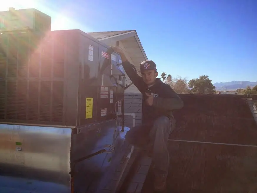 HVAC technician performing HVAC Inspection on a rooftop unit in Kingsburg